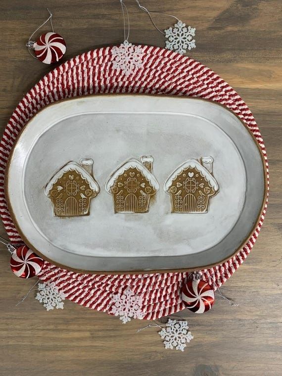 Juligt fat med tre pepparkakshus och polkagrisdekorationer